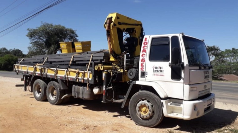 Caminhão munck da Sua Empresa carregado com vigas de aço